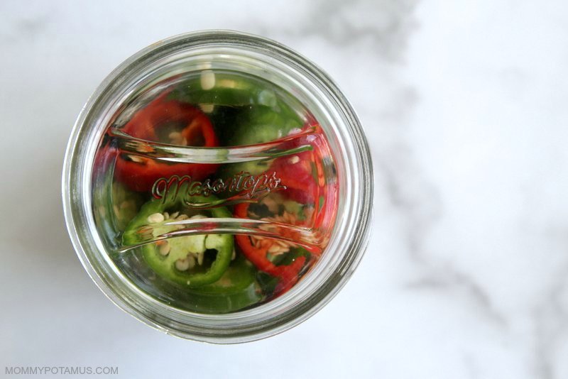 Topside view of fermenting weight in jar with fermented jalapenos