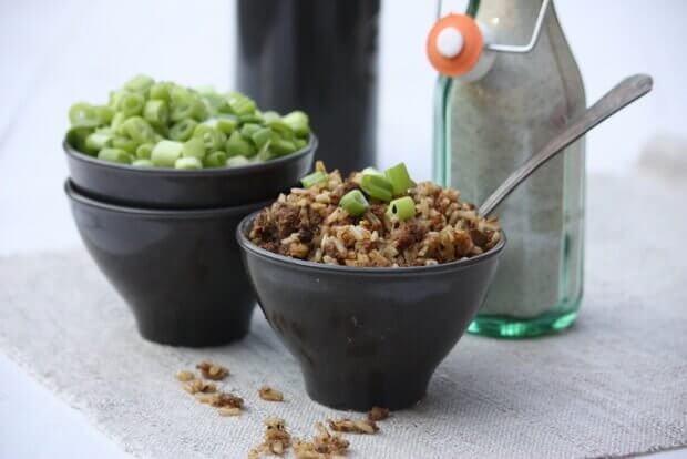 Bowl of dirty rice topped with green onion garnish