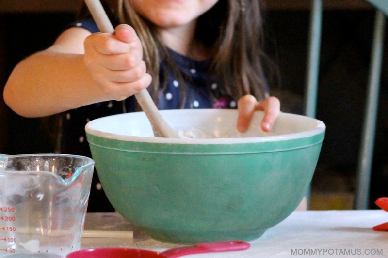 girl pouring water into the mixing bowl
