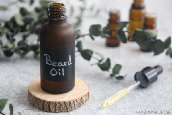 bottle of beard oil sitting on a round cut of wood