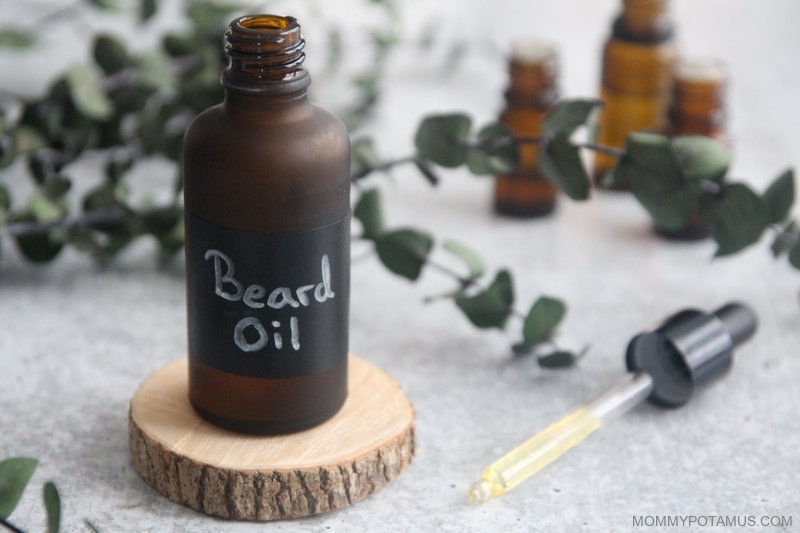 bottle of beard oil sitting on a round cut of wood