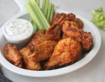 Crispy buffalo wings on plate with ranch dressing and celery sticks