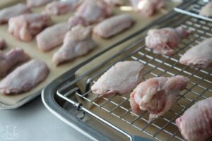 Chicken wings on baking sheet and baking rack