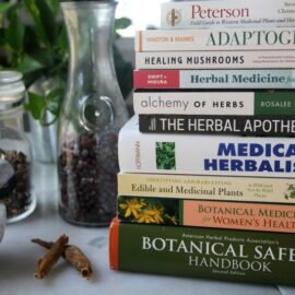 Stack of herbal books on table