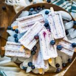 blueberry popsicles stacked in a bucket of ice