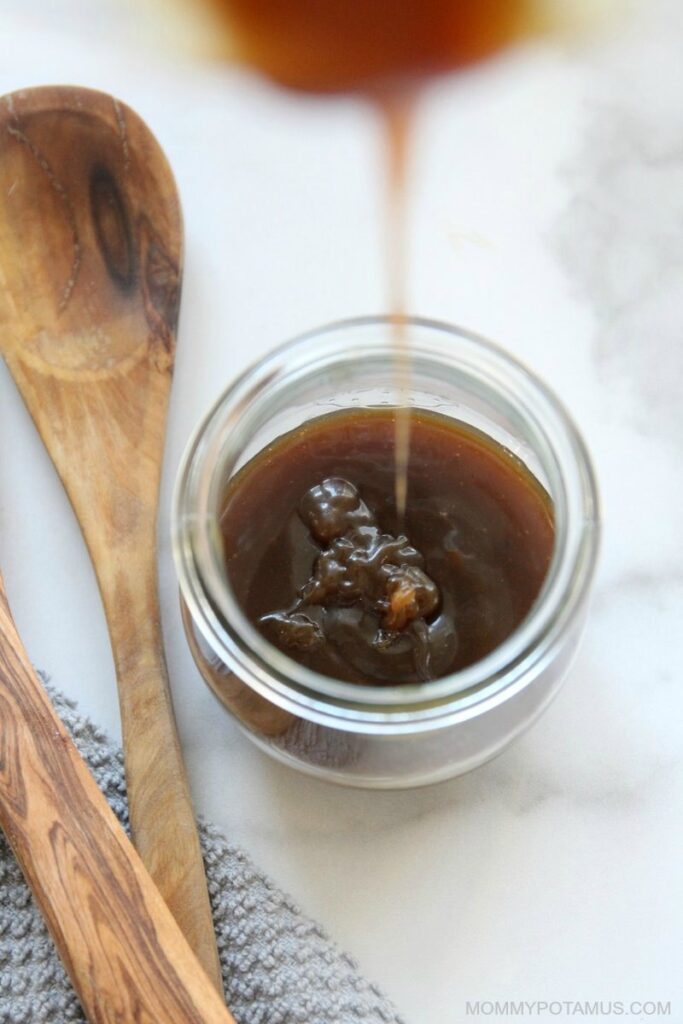 Overhead view of pouring dairy-free caramel sauce into a jar