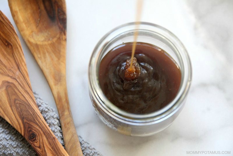 Pouring dairy-free caramel sauce into a jar