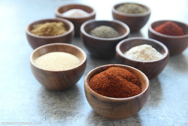 Individual spices in bowls (chilli powder, onion powder, garlic powder, paprika, oregano, cumin, salt and pepper)