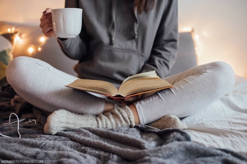 woman sitting cross-legged and reading a book