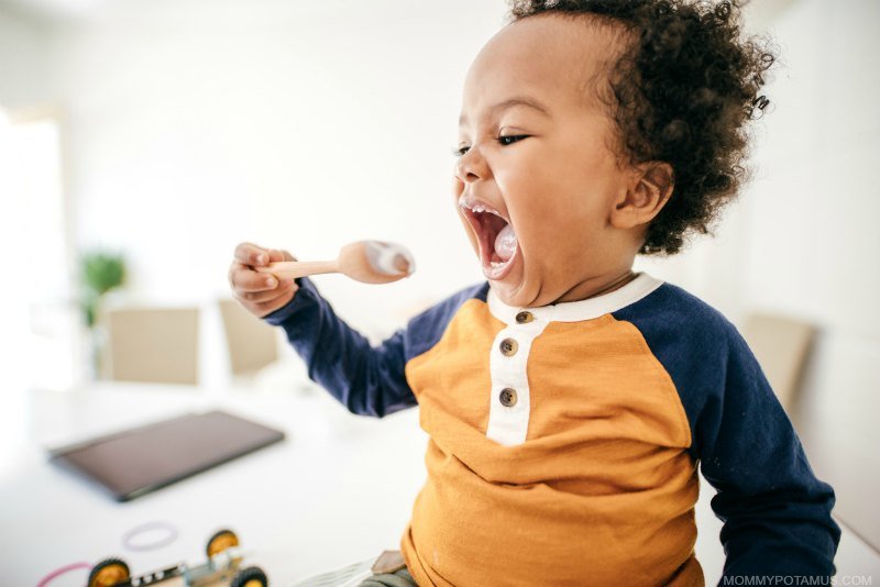 Baby feeding himself with spoon