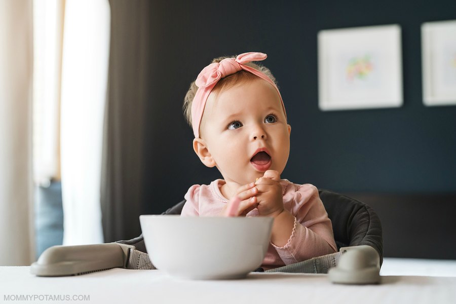 Baby girl eating in high chair