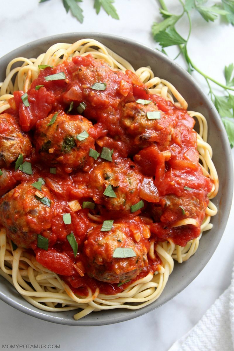 Overhead view of marinara sauce over meatballs