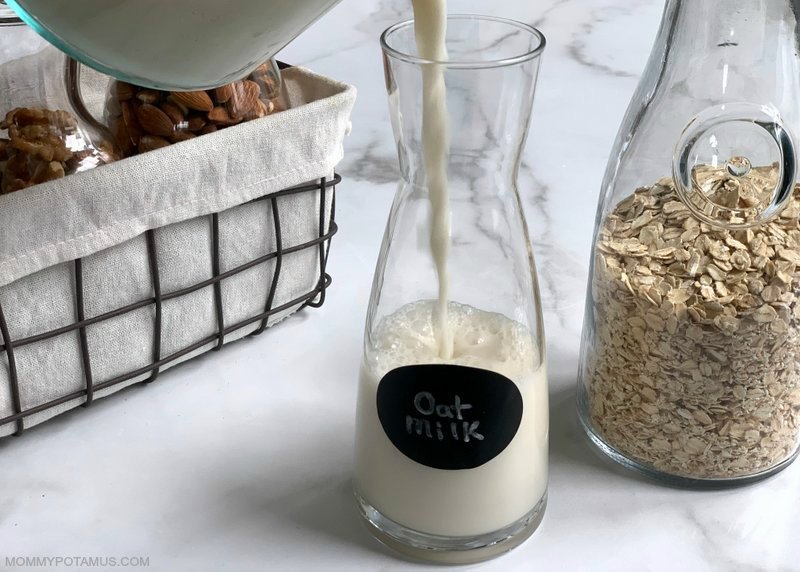 Pouring homemade oat milk into a carafe