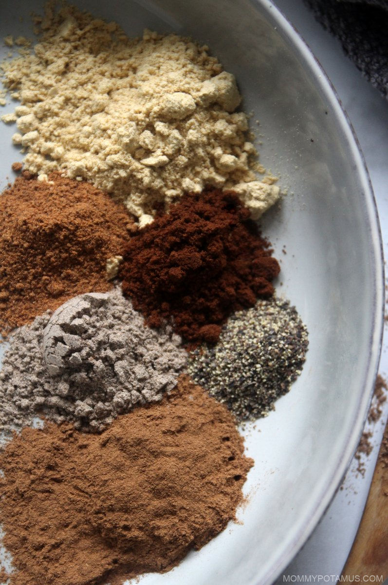 Overhead view of cinnamon, ginger, cardamom, allspice, nutmeg, clove and black pepper spices ready to be blended. 