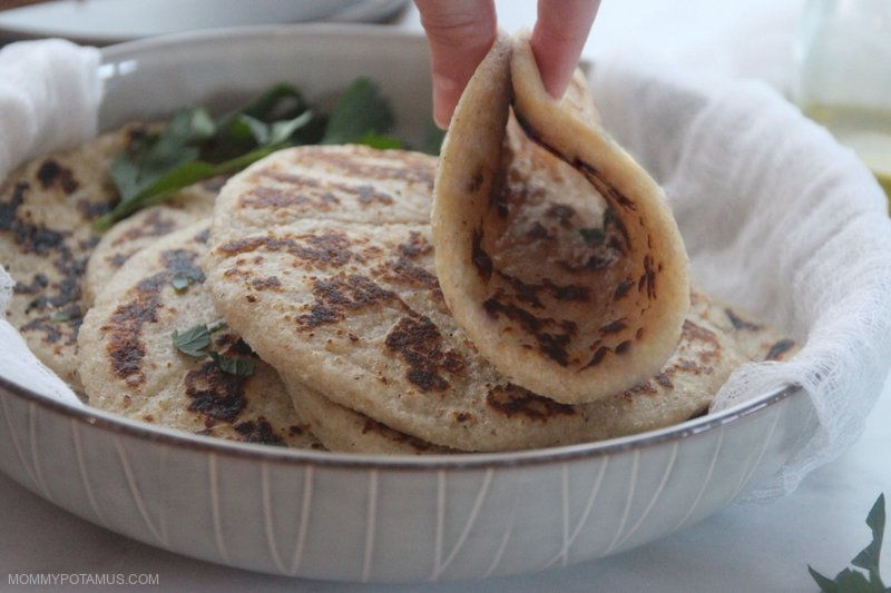 Hands picking up pliable folded gluten-free flatbread