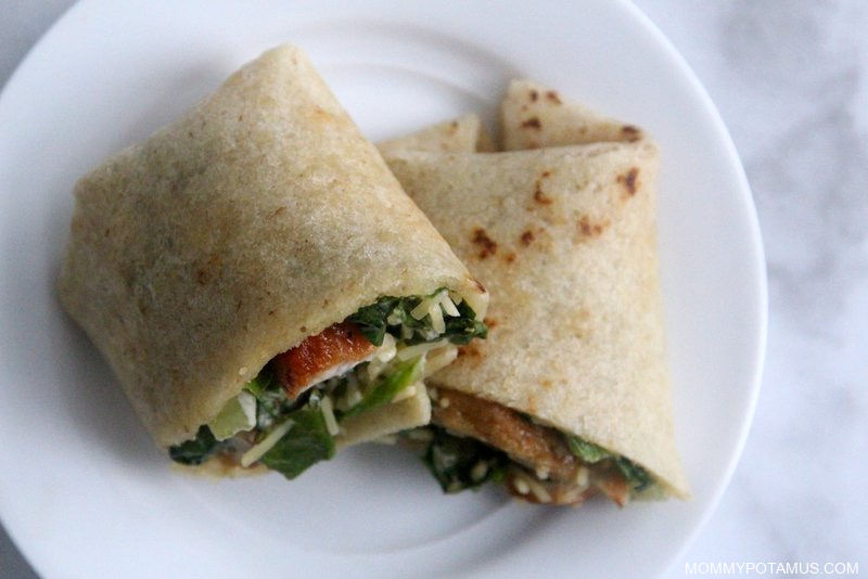 Overhead view of chicken caesar wraps on a plate. 