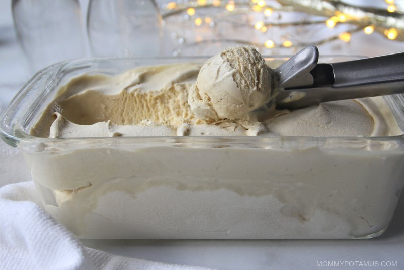 Scooping dairy-free eggnog ice cream out of container