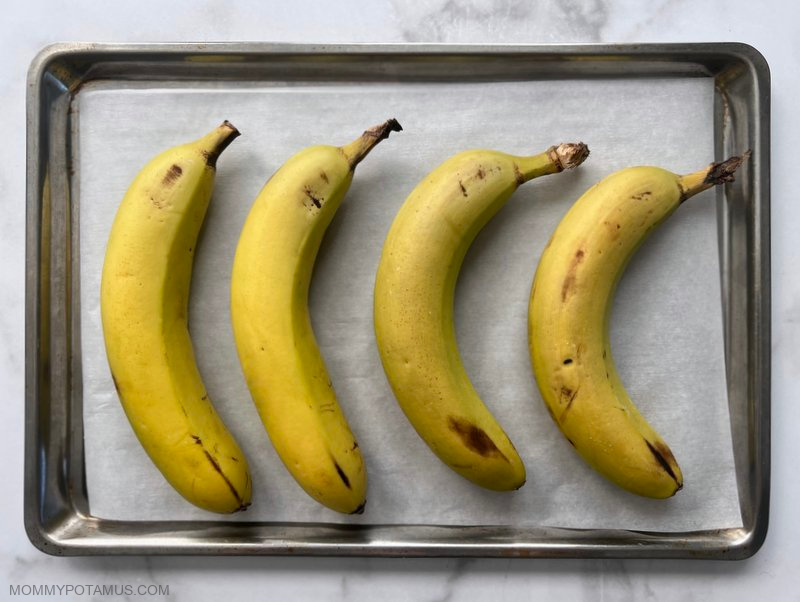 Unripened bananas on baking sheet