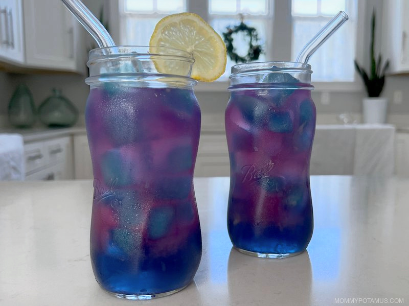 Two glasses of butterfly pea flower lemonade with blue ice cubes
