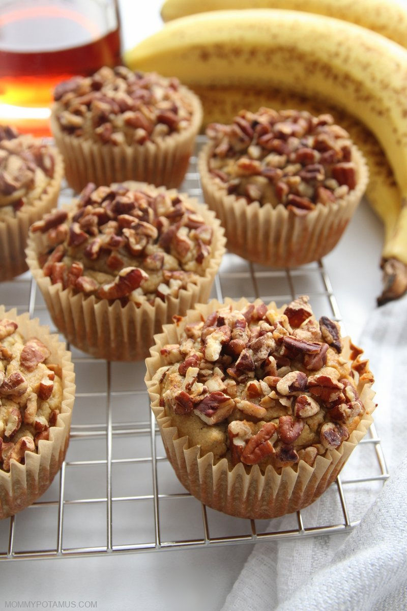 Overhead view of gluten-free banana nut muffins on cooling rack next to fresh bananas