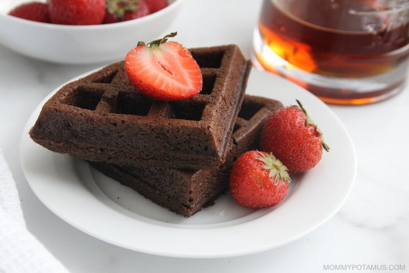Stack of chocolate waffles with a strawberry on top
