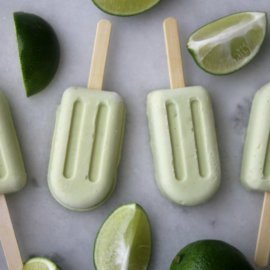 Key lime pie popsicles on marble countertop