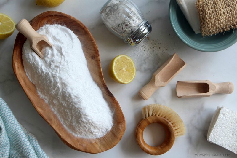 Baking soda next to lemons, ready to be used for cleaning or natural remedies