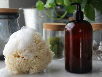 Homemade body wash on table with natural sponge and suds