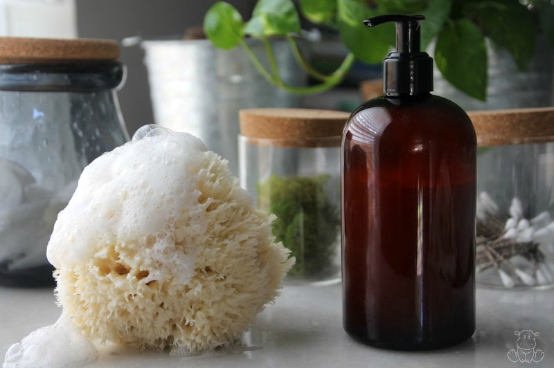 Homemade body wash on table with natural sponge and suds