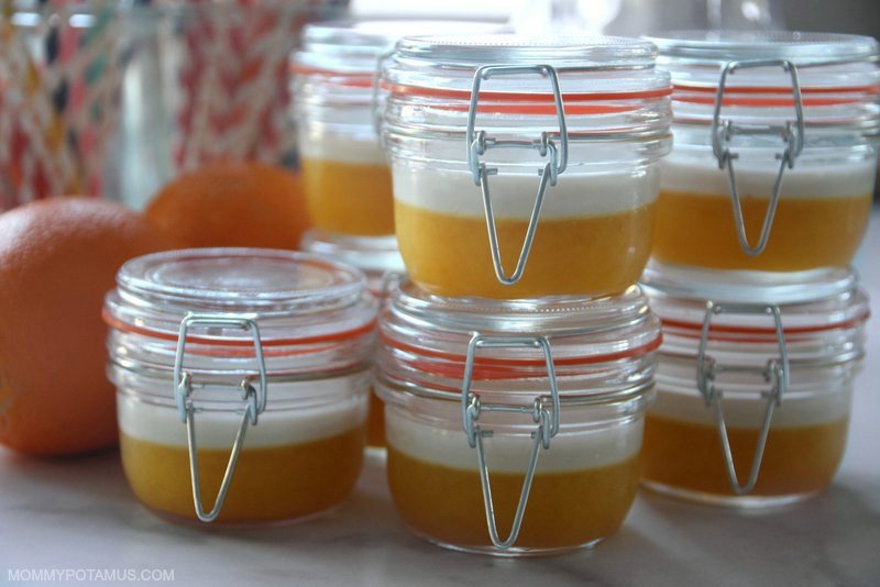 Jars of homemade gelatin cups on counter next to oranges