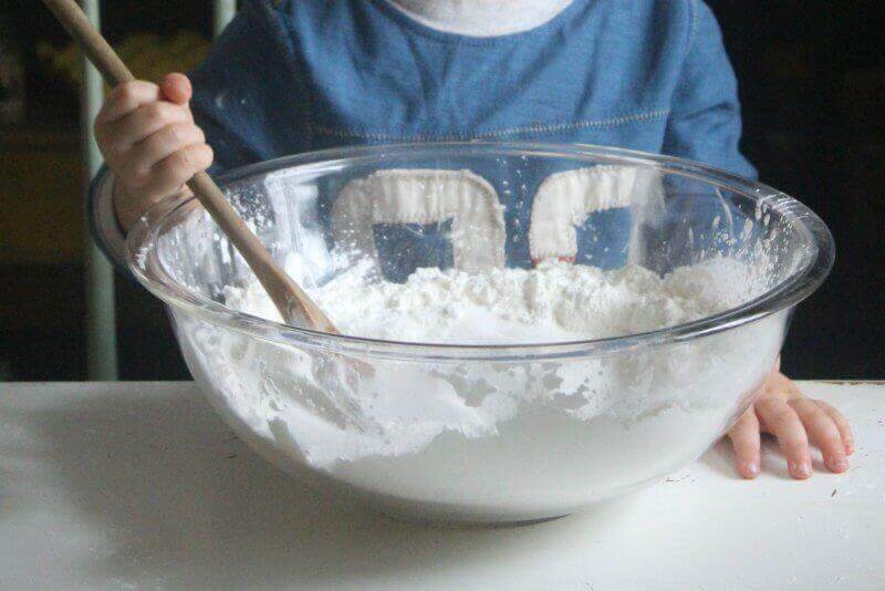 boy mixing the cornstarch in a mixing bowl