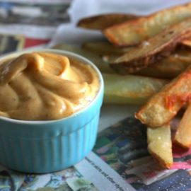 French fries on a table beside a ramekin of chipotle mayo